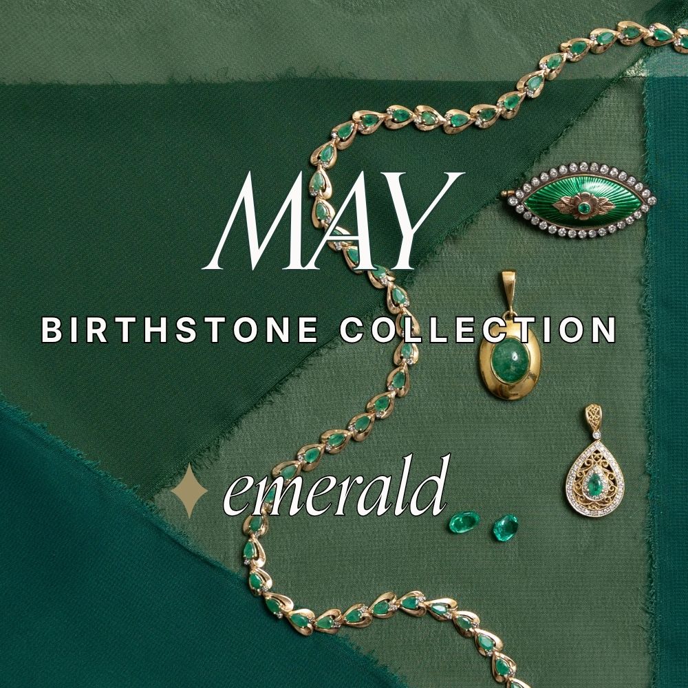 Flat lay of the May Birthstone Collection featuring a vintage, gold emerald bracelet, vintage emerald pendants, and an oval green enamel brooch on dark green chiffon.