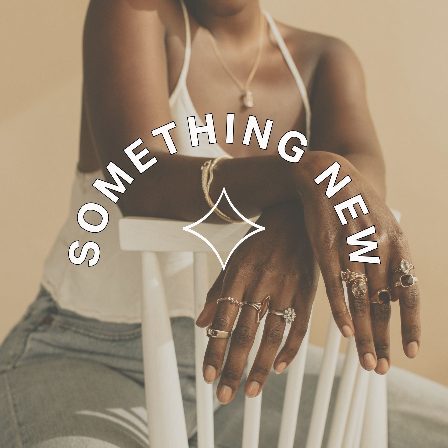 Hand with rings on a blurred background with text overlay: something new