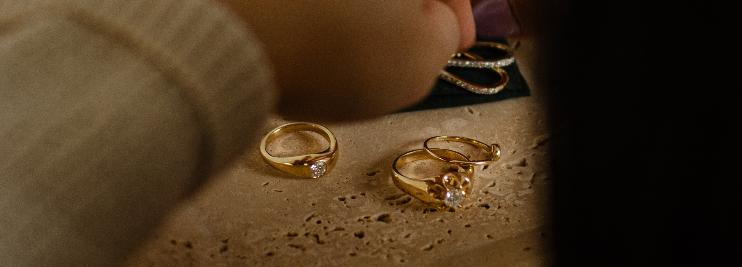 Modern, contemporary rings made from recycled gold and reclaimed diamonds styled in a neutral travertine tray. Sustainable fine jewellery