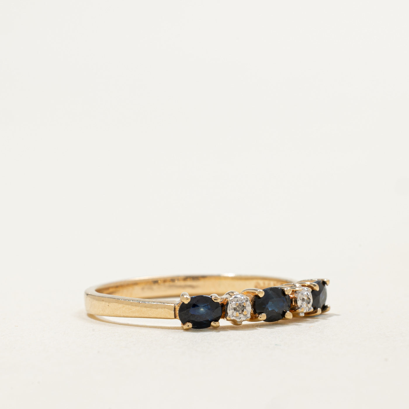 Bague en or 10 carats sertie de cinq saphirs et diamants | 0,54 ct au total, 0,01 ct au total | Taille 9