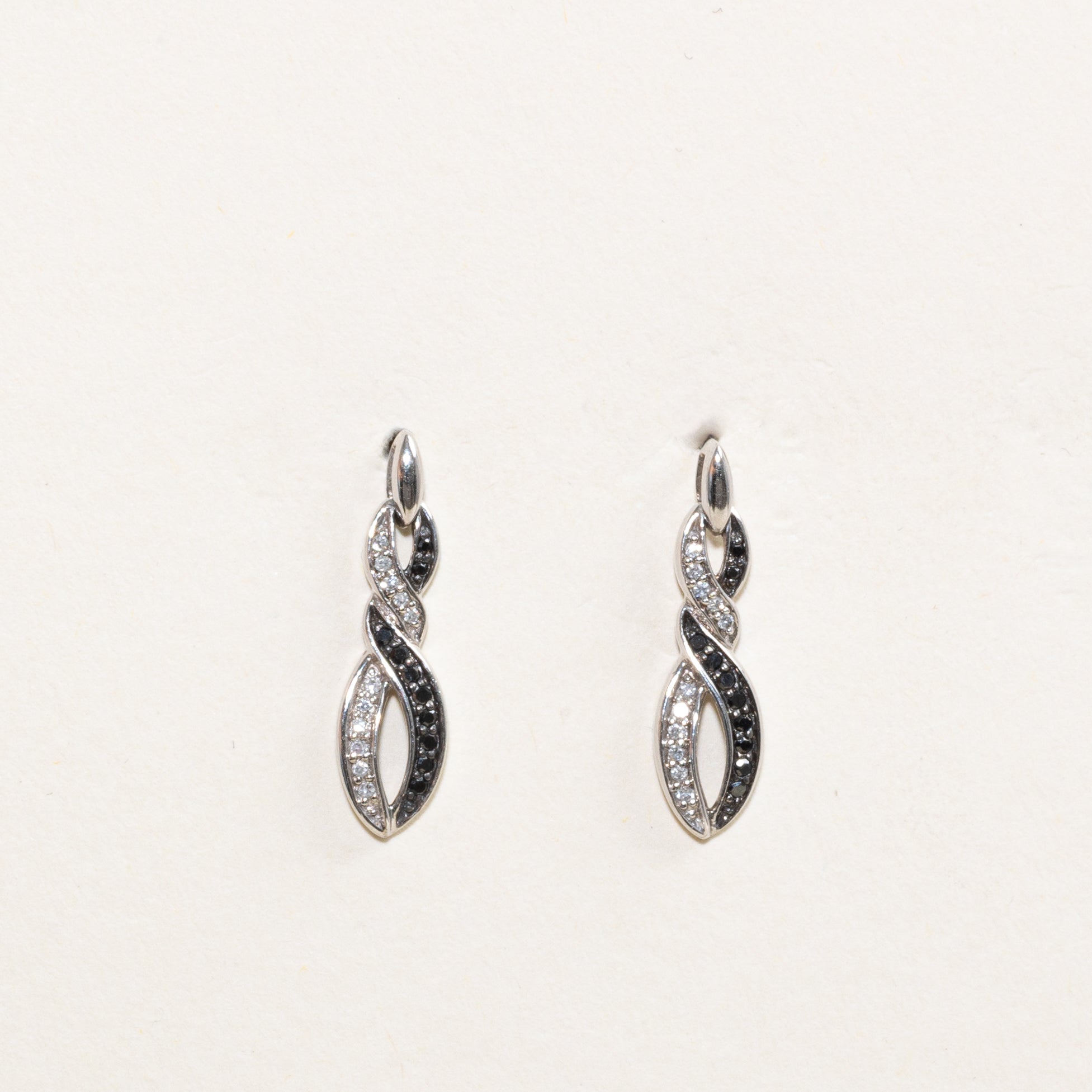 Boucles d'oreilles pendantes croisées serties de diamants noirs et blancs pavés