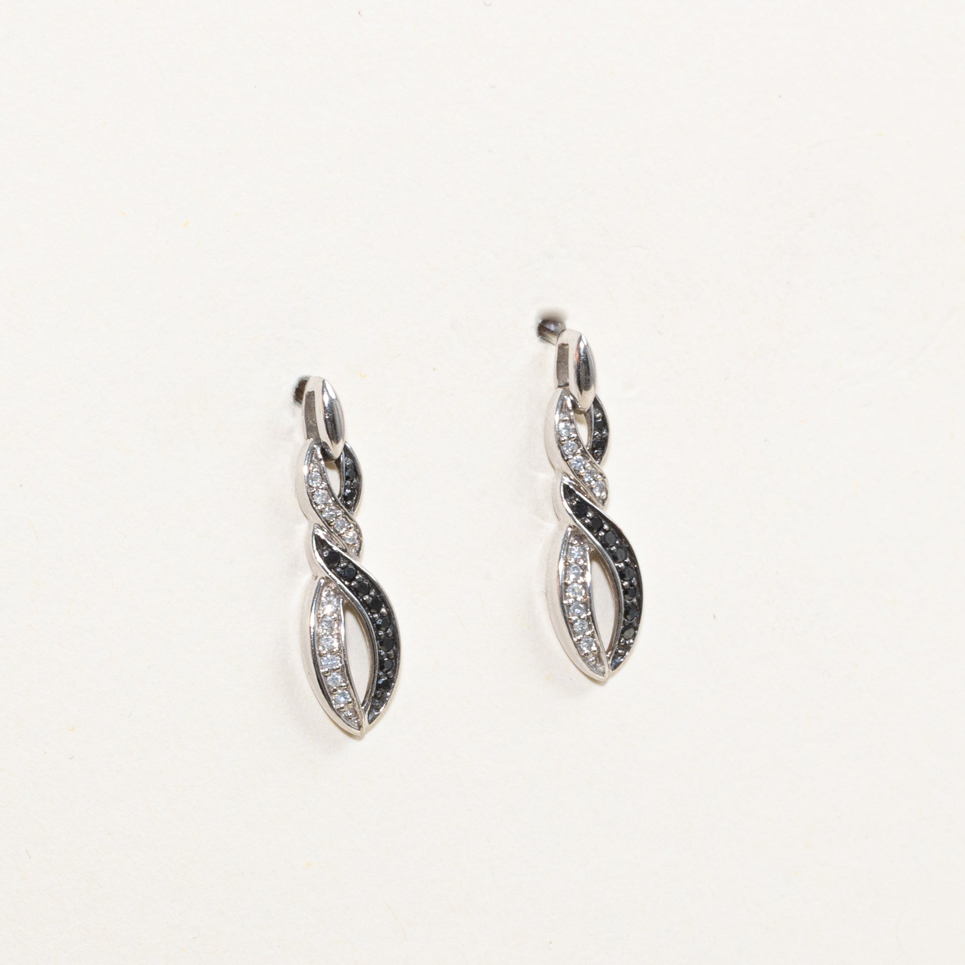 Boucles d'oreilles pendantes croisées serties de diamants noirs et blancs pavés