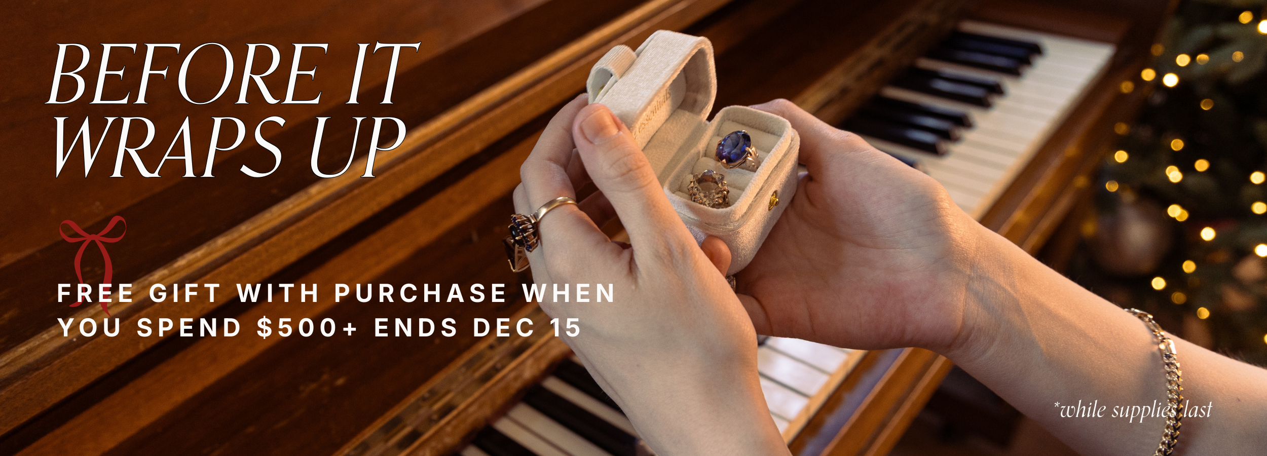 Close-up of hands holding a velvet jewellery box with preloved vintage rings, styled on a piano for a holiday jewellery gift with purchase promotion.