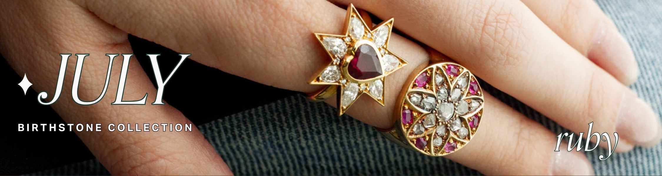 Two gold and ruby gemstone rings on a hand resting on denim, text over reads: july birthstone collection, ruby