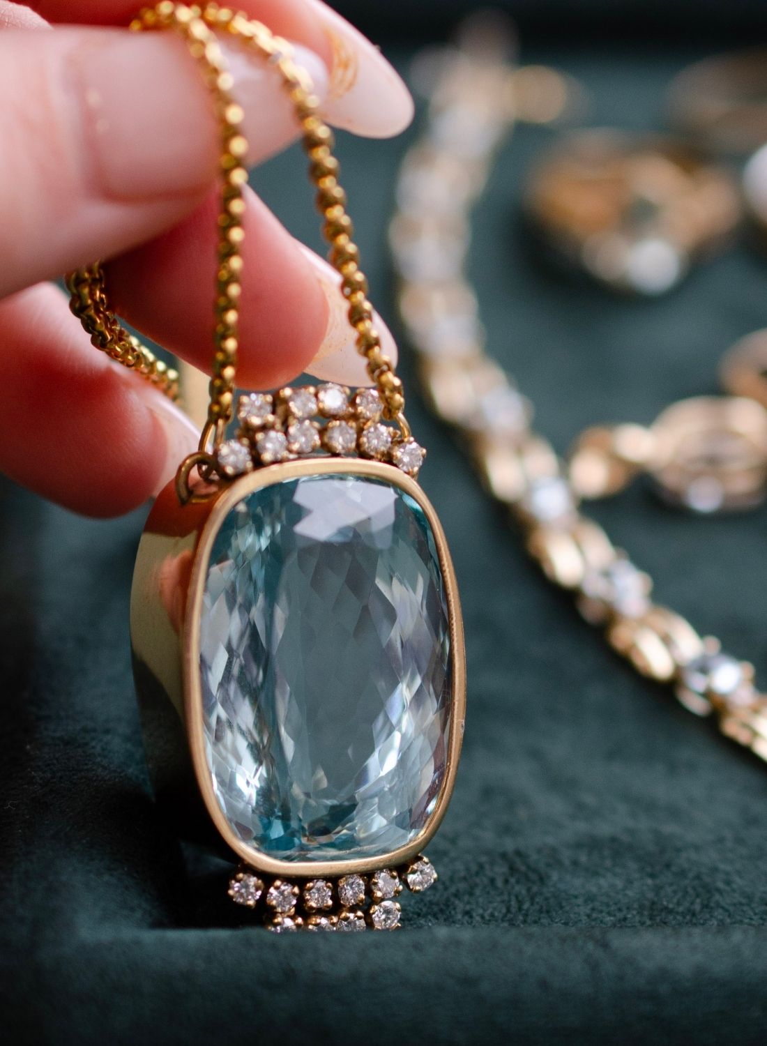 Large statement, aquamarine pendant necklace in yellow gold with diamond accents along the perimeter of the bezel.