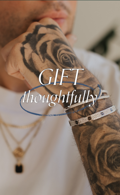 Close up image of tattooed hand wearing preloved, designer, white gold bracelets. Text reads: Gift thoughtfully
