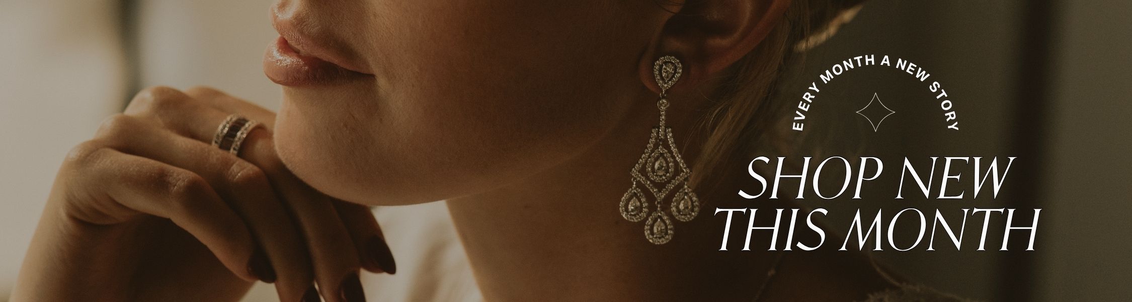 Close-up of a woman's face wearing vintage drop earrings with text: every month a new story' shop new this month