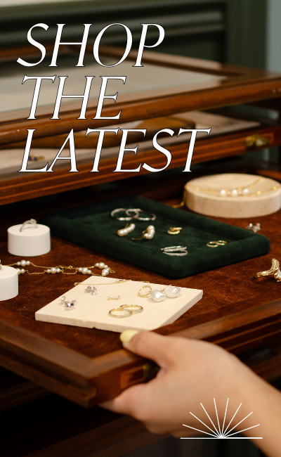 Vintage jewellery tray featuring display of rings, bracelets and earrings. Text reads: Shop the latest