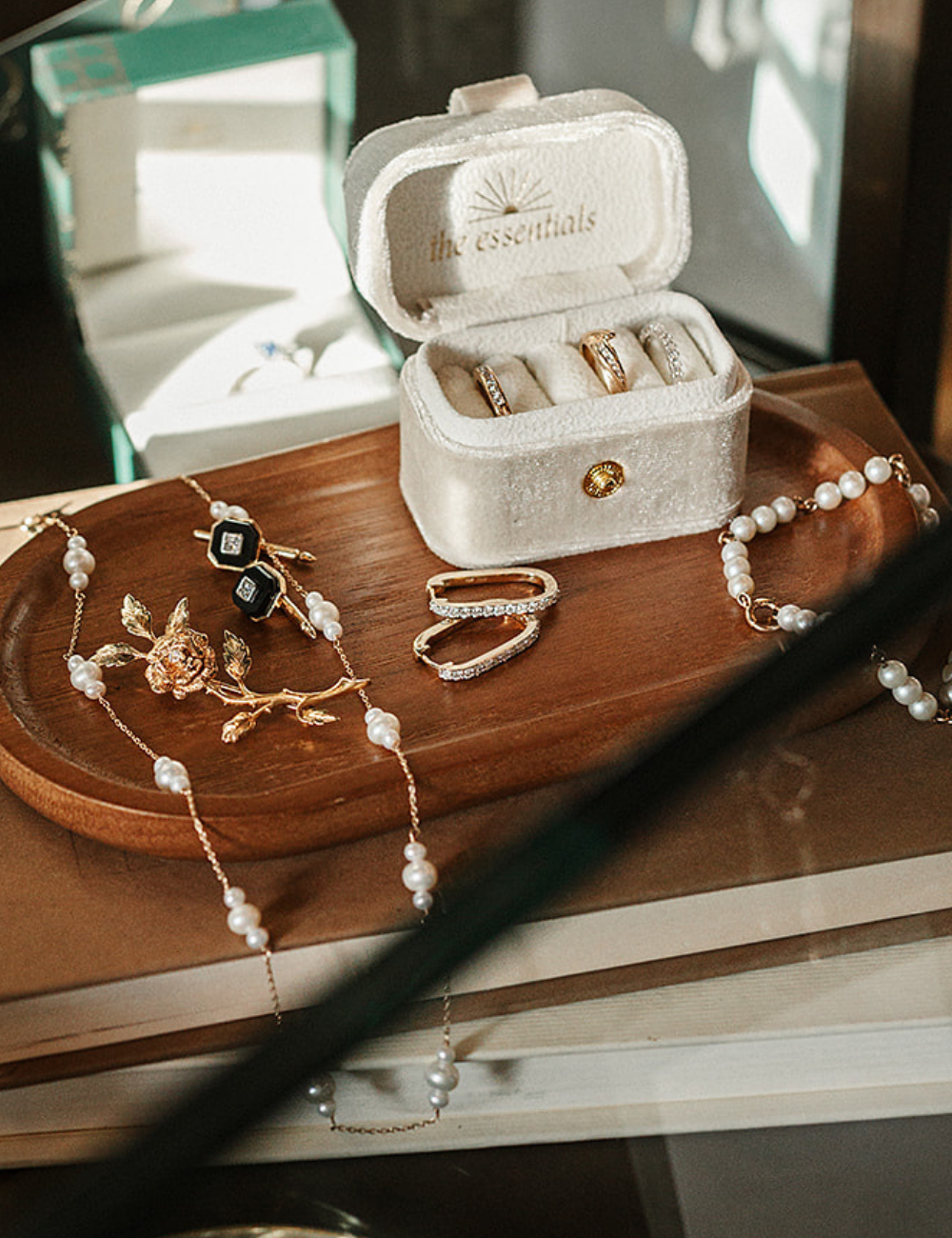 Modern pearl necklace with vintage gold and diamond rings displayed beside a velvet ring box