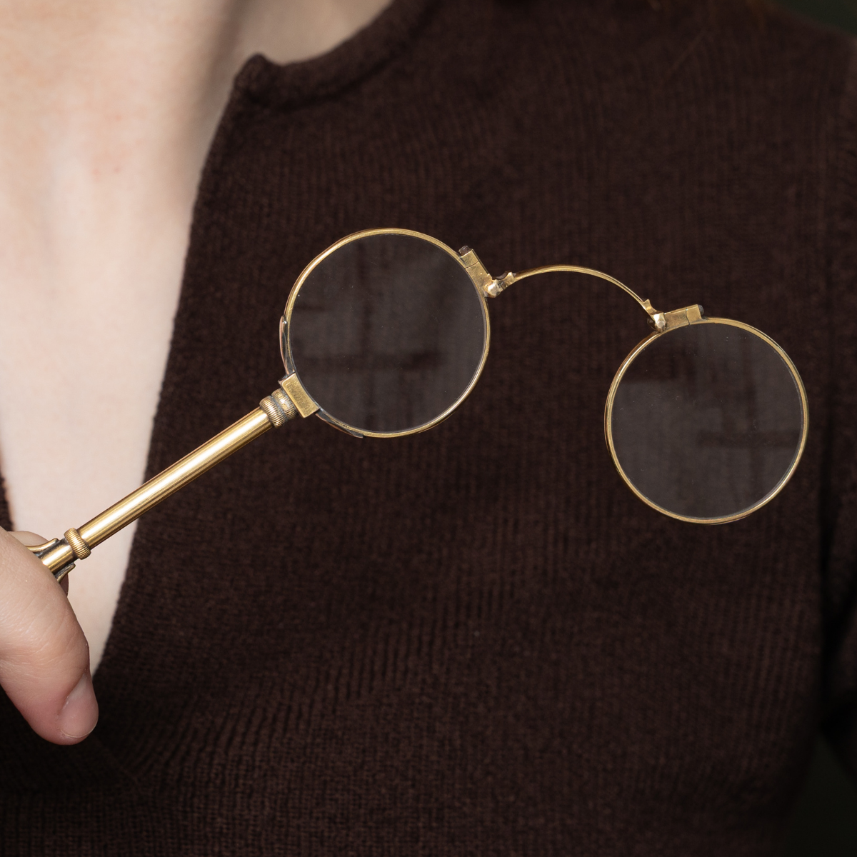 Close-up of antique gold lorgnette glasses, a timeless vintage accessory symbolizing old-world charm and craftsmanship.