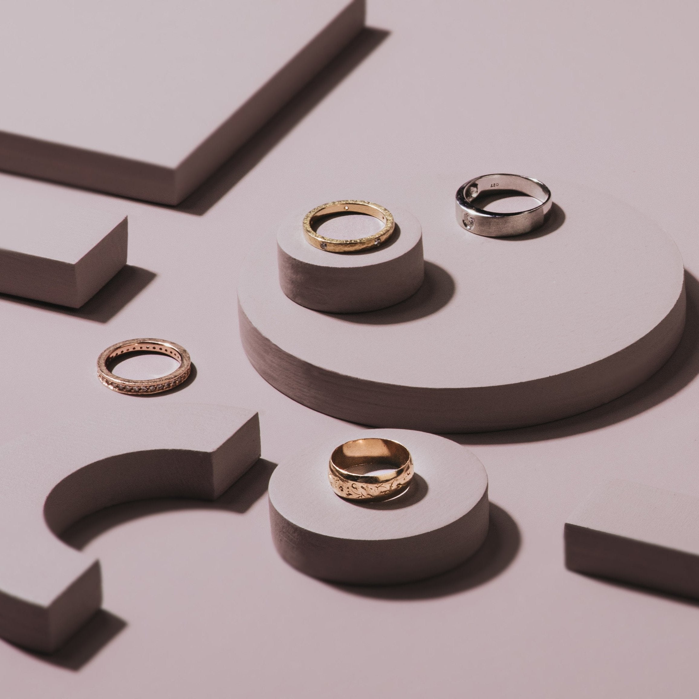 image of unique wedding bands on arch and circle props in mauve colours