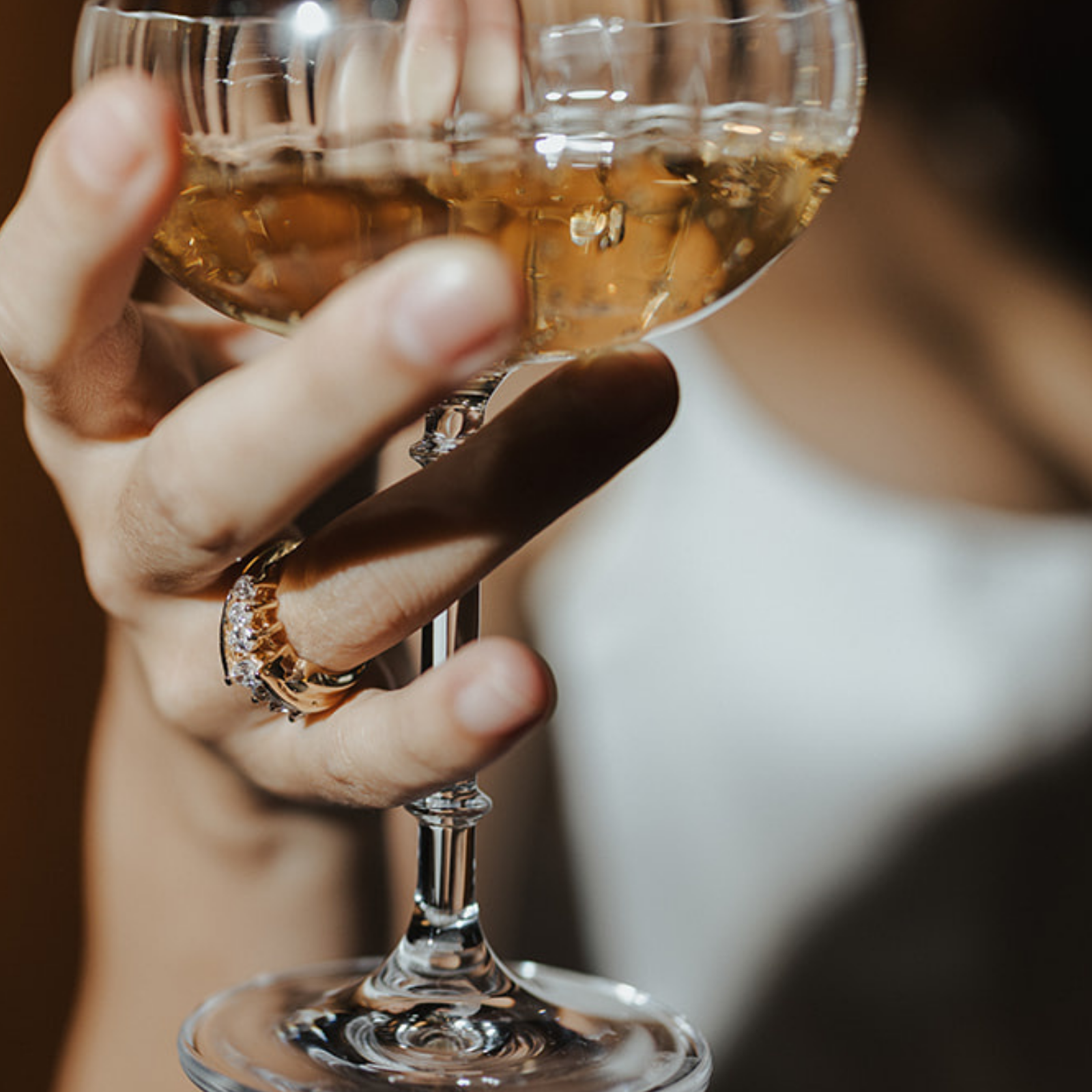 Unique, vintage yellow gold wedding band set worn while holding a champagne glass