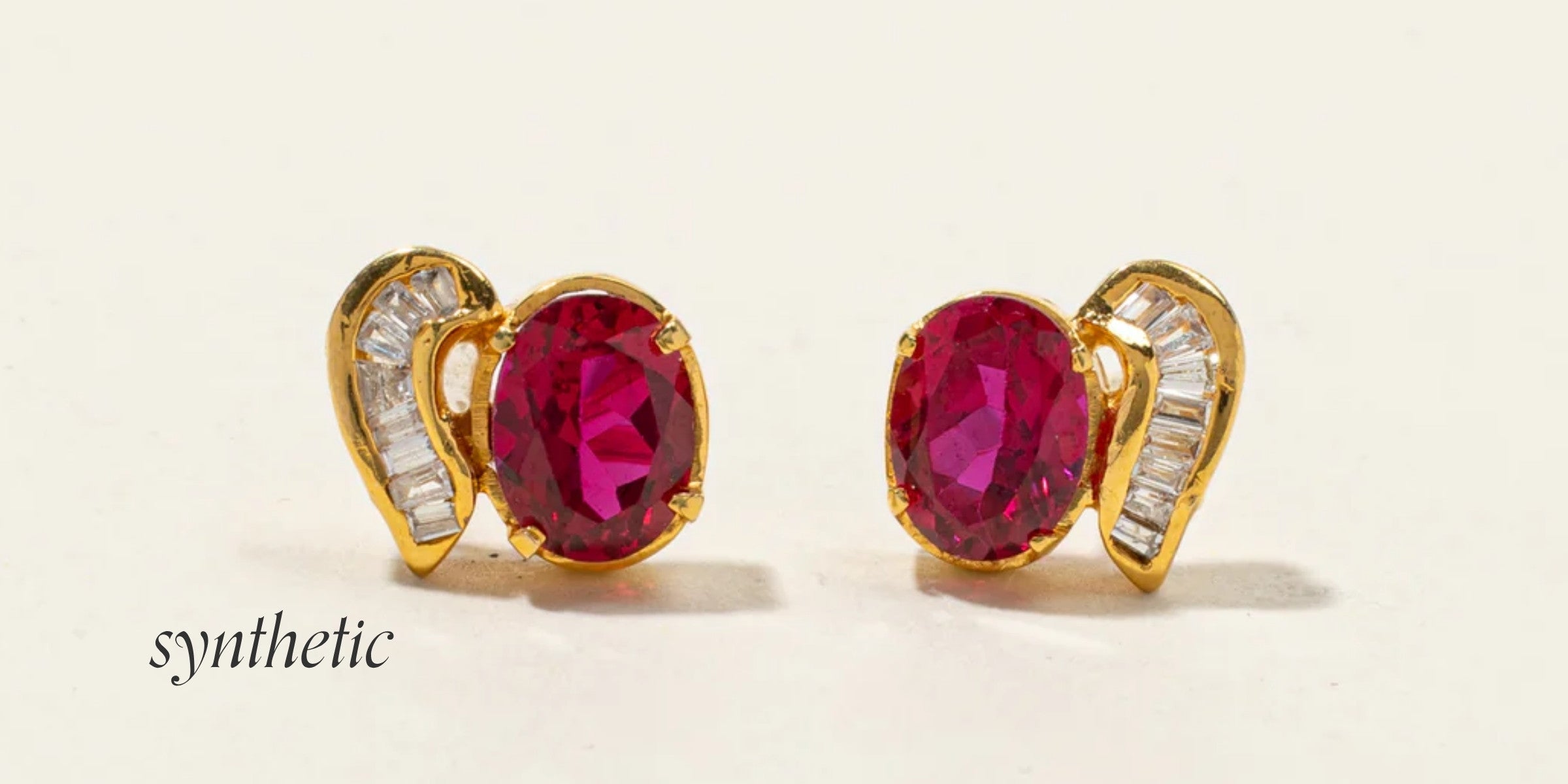 Preloved yellow gold cocktail earrings with synthetic oval rubies and baguette diamond accents, highlighting the high clarity and vivid color of simulated vintage gemstones.