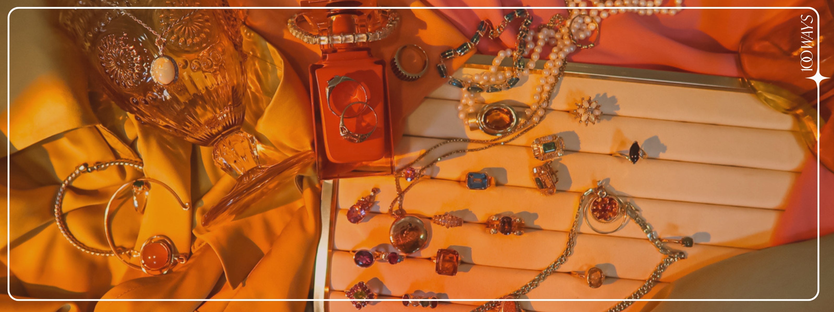 image of colourful fine jewelry in golden light, surrounded by brightly coloured fabrics and decor