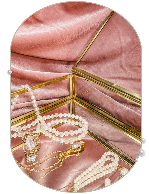 pearl essence jewellery collection pearl jewellery in glass and gold jewellery box on a pink velvet backdrop