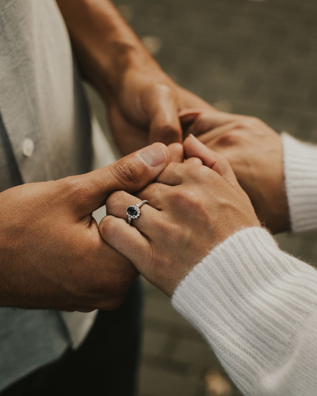 image of couple holding hands after proposal with a vintage sapphire engagement ring, image from the 100 ways gemstone engagement rings collection