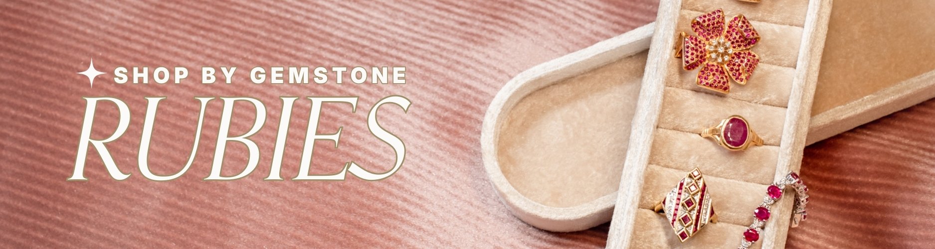 cream velvet Jewelry box displaying ruby jewelry including floral earrings studded with rubies, a vintage ruby bezel set ring, a ruby tennis bracelet + a geometric ruby + diamond ring. on pink background, text overlay: 'Shop by Gemstone, Rubies'