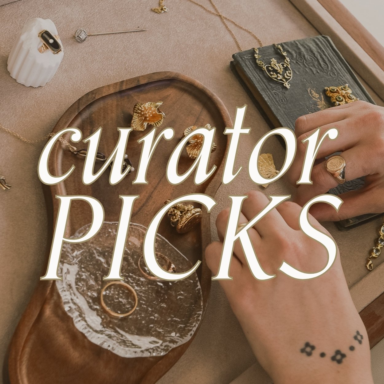 image of woman arranging gold and gemstone vintage jewellery on display tray, text over reads 'curator picks; hand selected collections from guest curators and staff'