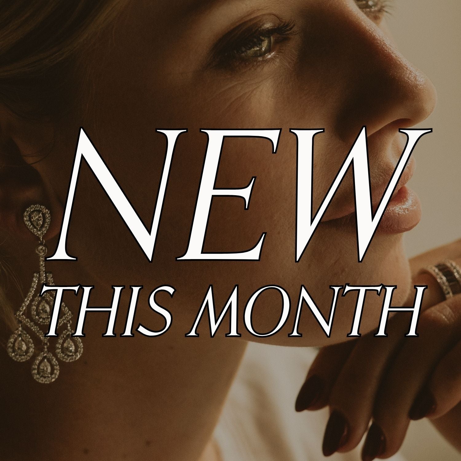 Close-up of a woman's face wearing vintage drop earrings with text: new this month