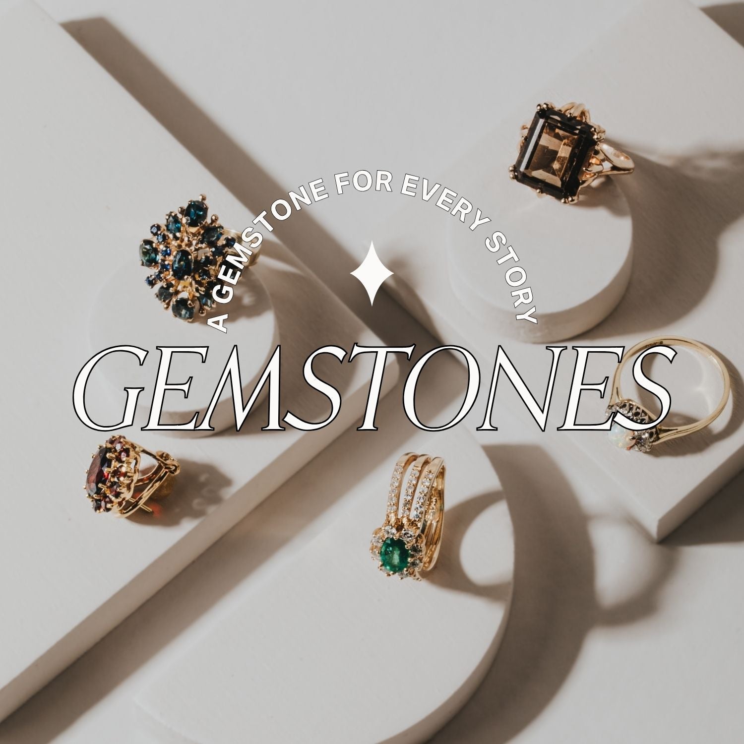 Jewelry display with gemstone rings on a white background, featuring the text 'a gemstone for every story'.