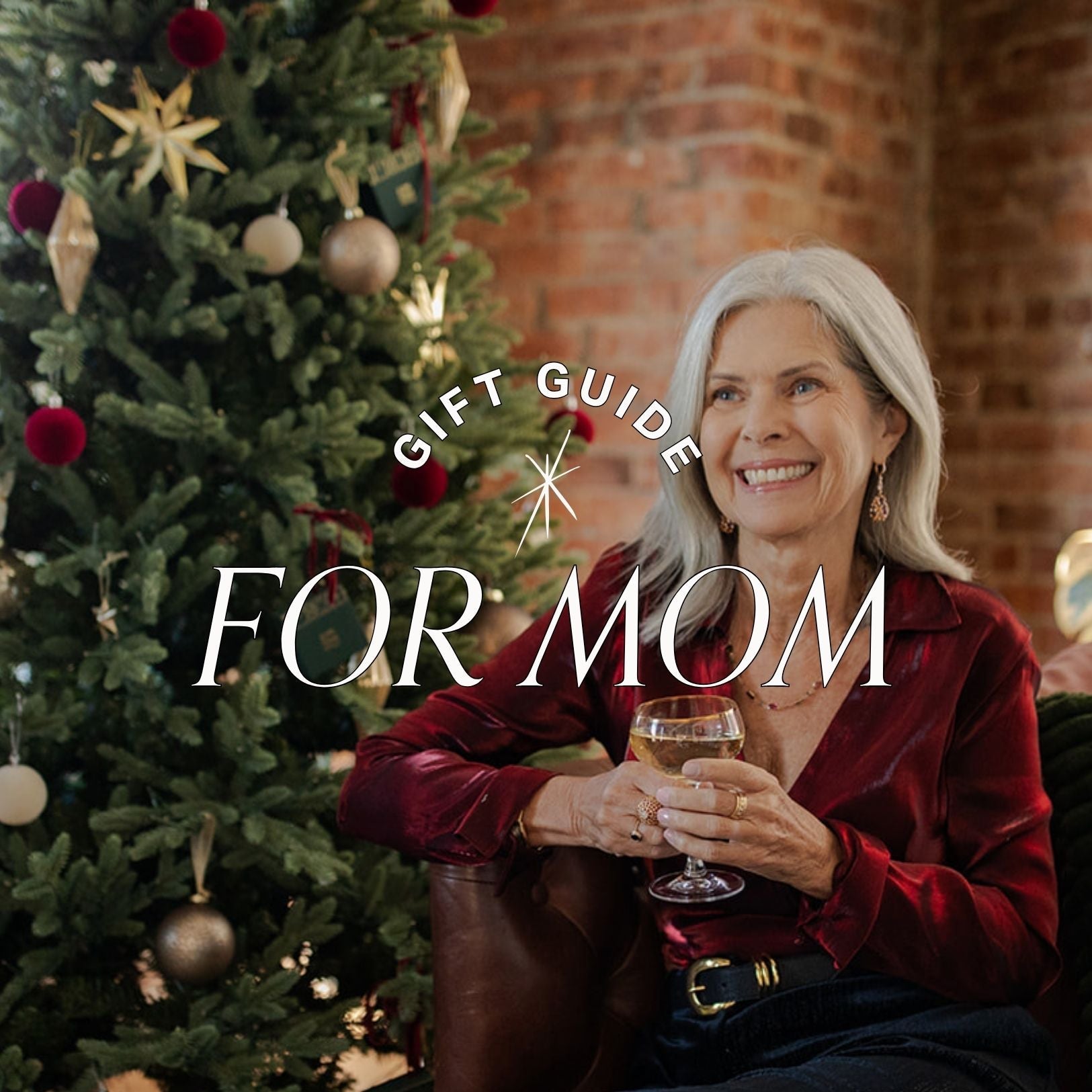 Woman holding a glass of wine in front of a Christmas tree with 'Gift Guide for Mom' text overlay.
