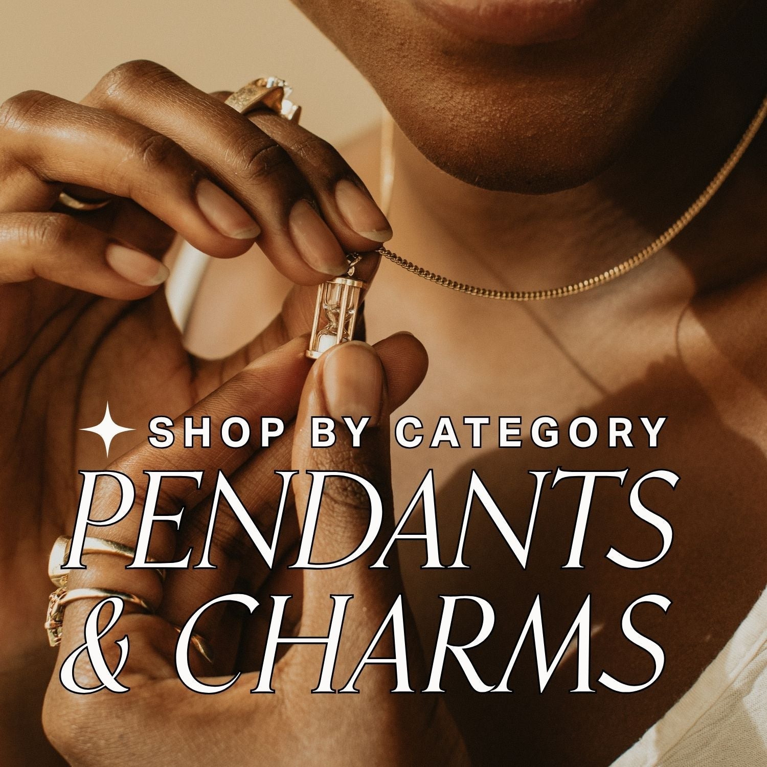 Person holding an hourglass pendant on a gold chain with text 'shop by category: Pendants & Charms' on a beige background