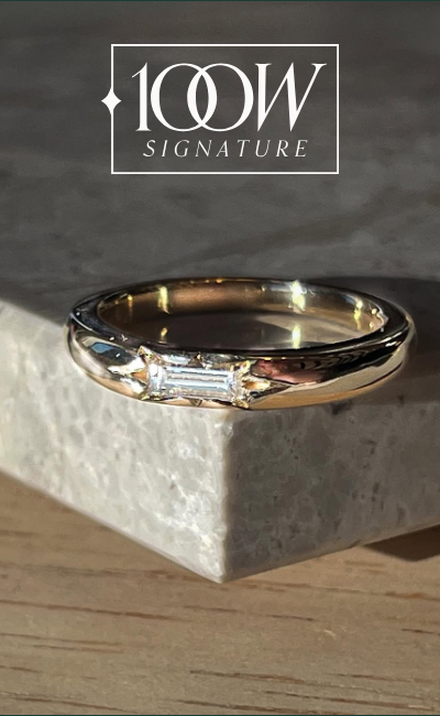 Yellow gold ring with a baguette diamond in a star setting, featuring the '100W Signature' brand.