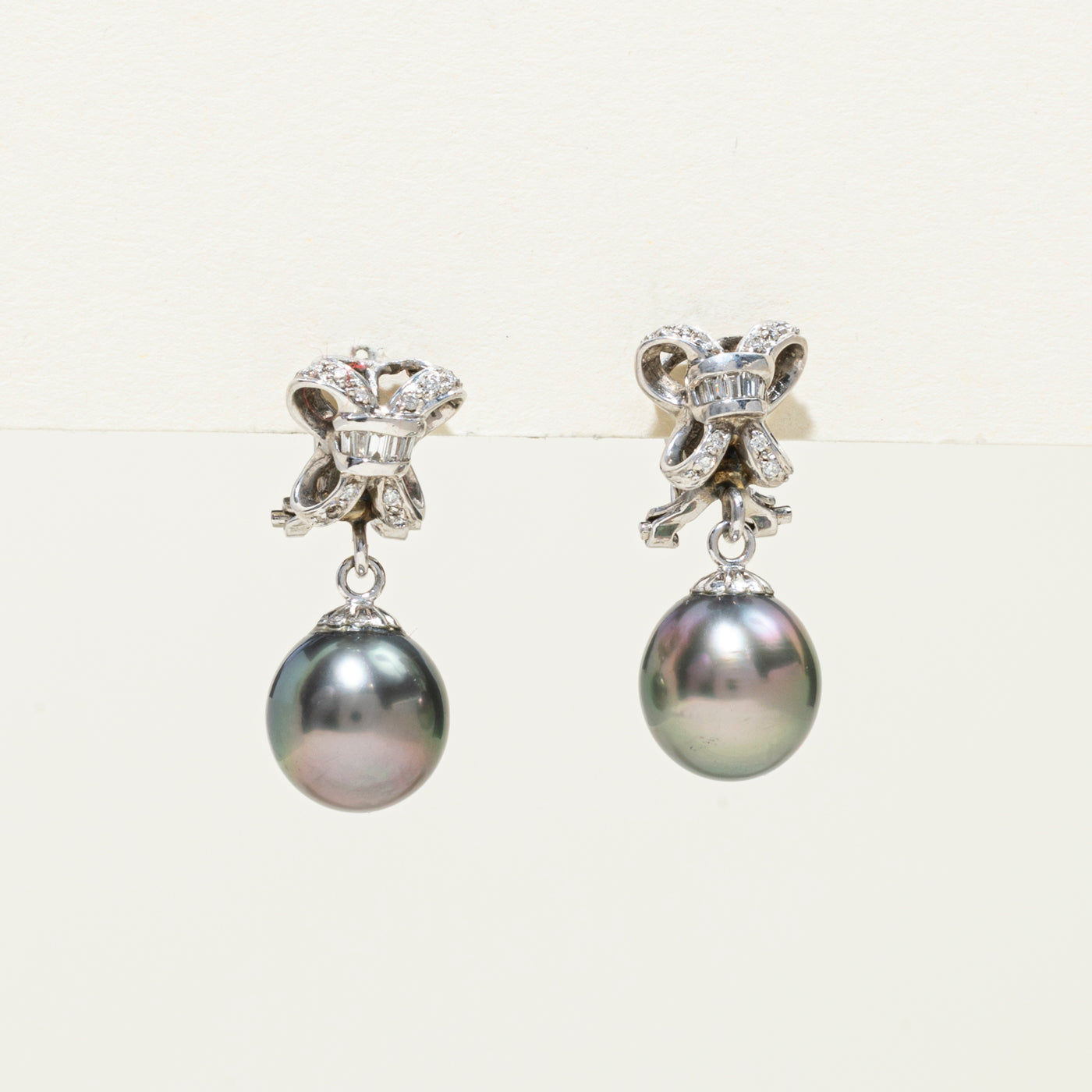 Boucles d'oreilles pendantes nœud en perles noires 18 carats et diamants | 0,20 ct