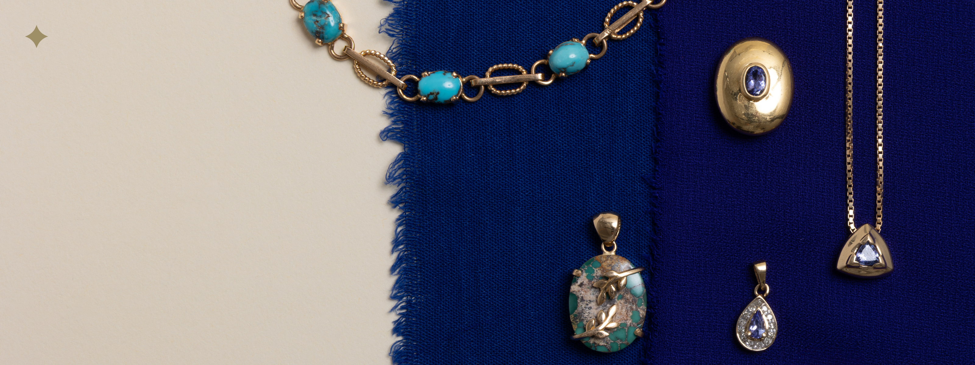 Flatlay of vintage December birthstone jewellery featuring tanzanite, turquoise, and blue zircon pieces styled on deep blue fabric—preloved and antique gold settings.