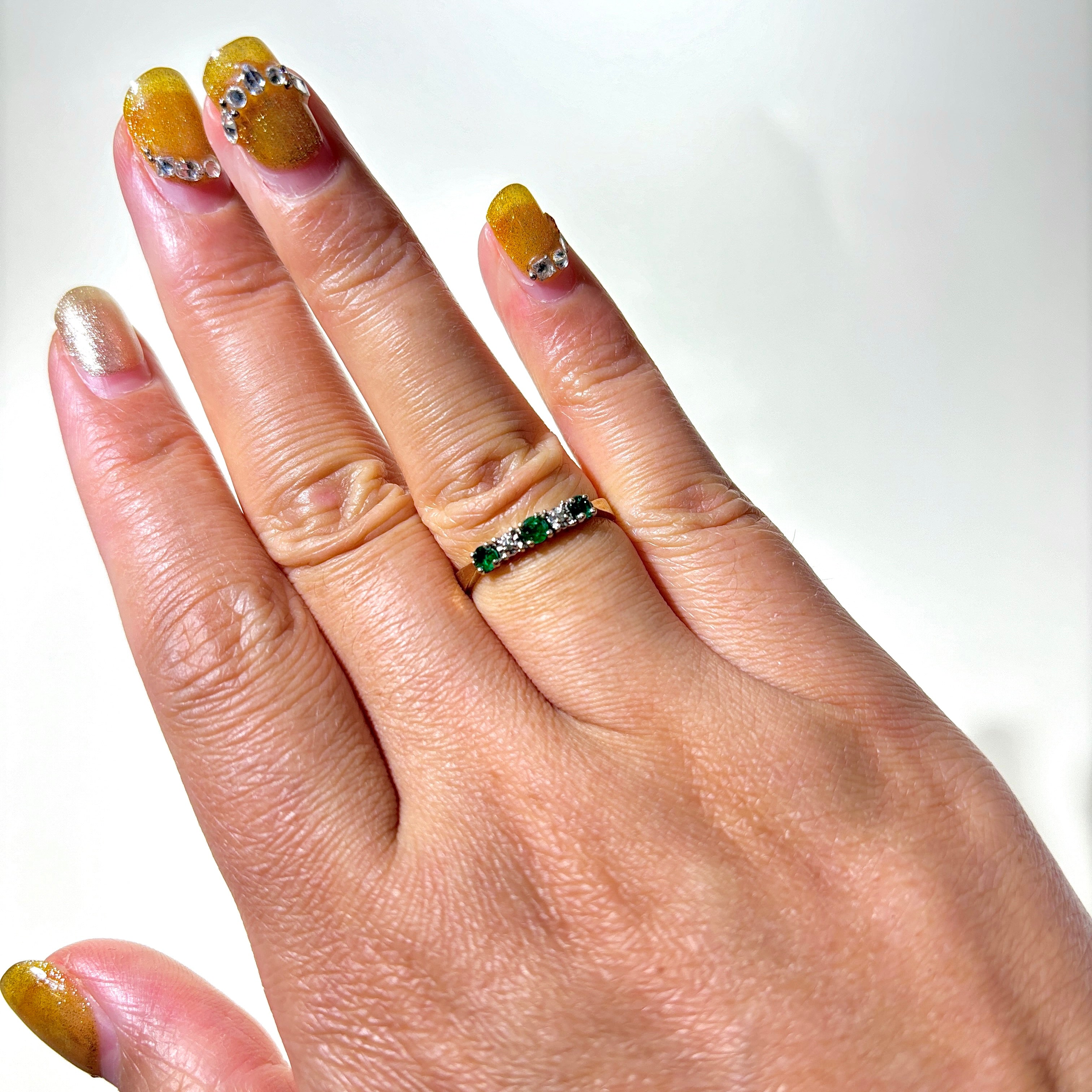 Bague cinq pierres en or 10 carats, émeraude et diamants | 0,14 ct au total, 0,01 ct au total | Taille 5,75 
