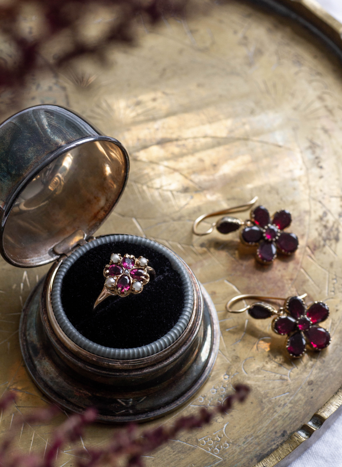 January birthstone garnet jewellery featuring antique, yellow gold rings and floral shaped drop earrings with deep red stones.