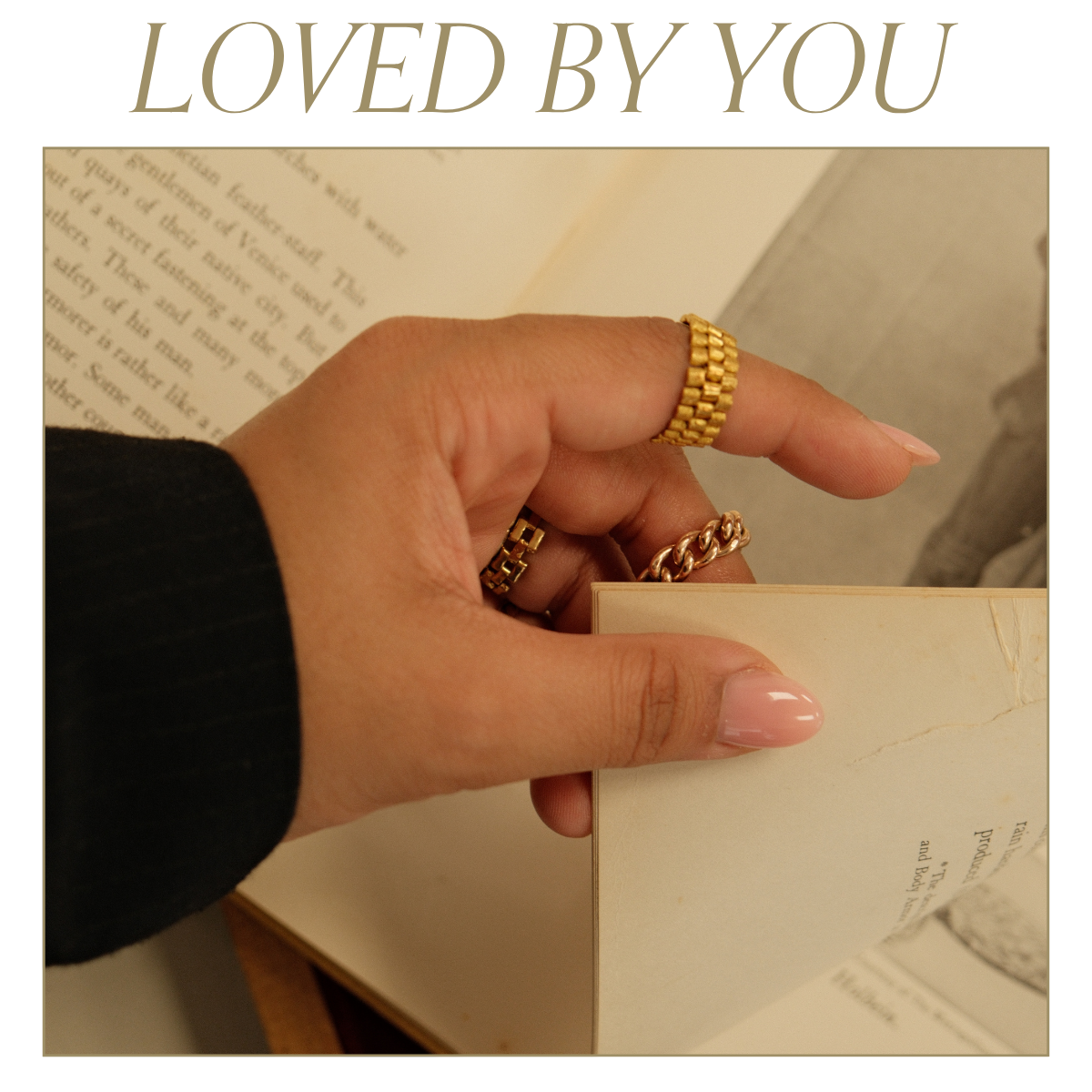 Close up image of turning a page. Model wearing a variety of yellow gold chain rings. Text reads: Loved by you