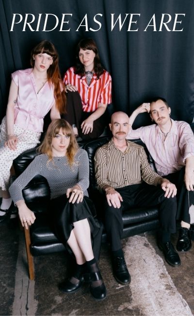 A diverse group of five people posing together on a black leather couch for a pride jewellery campaign. Text reads: Pride as we are