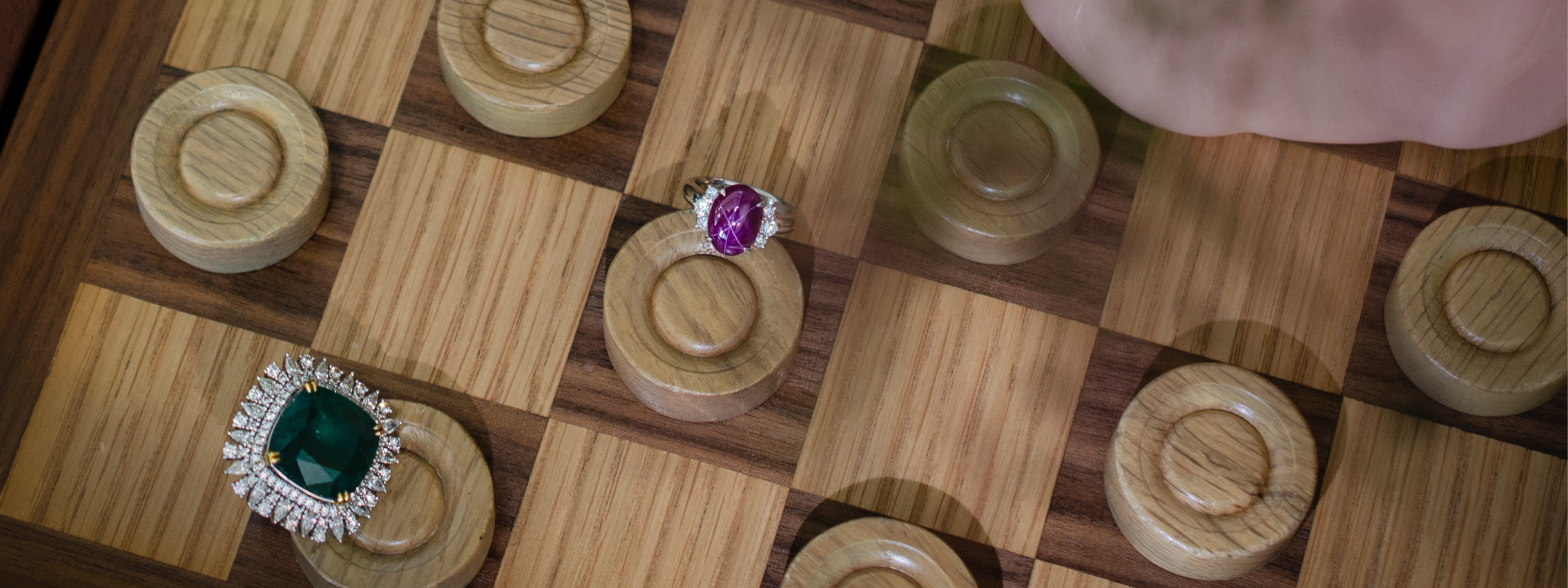 Wooden checker board with high jewellery , vintage rings on pieces