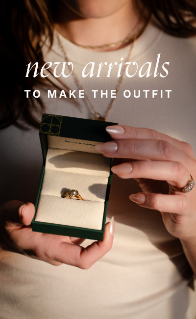 Text reads: "new arrivals to make the outfit." Close up of hands holding open a dark green jewelry box to reveal a preloved vintage gold and pearl ring.