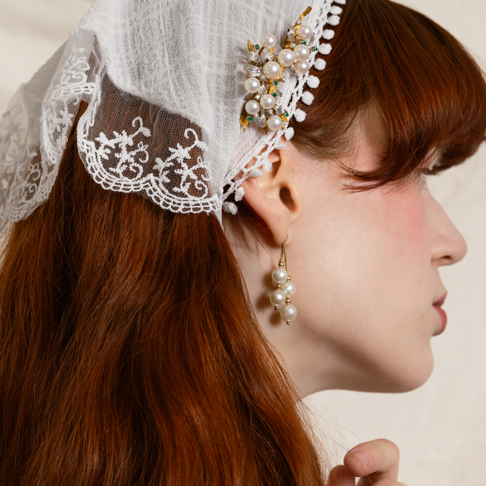 Vintage pearl drop earrings worn with lace headpiece with antique pearl brooch, featuring classic bridal jewellery style