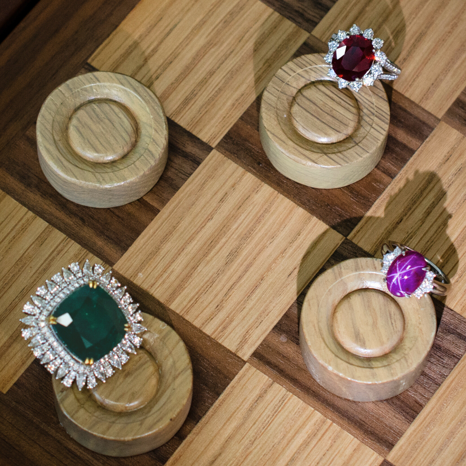Luxurious, preloved gemstone cocktail rings on wooden checkerboard