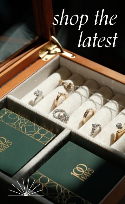 Wooden jewellery box with assorted vintage jewellery displayed. Text reads: Shop the latest
