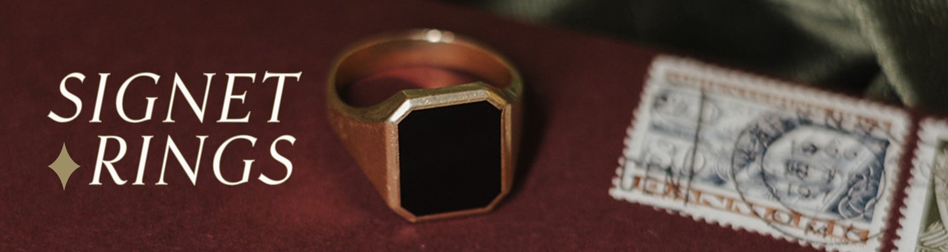 Gold signet ring with an onyx stone on a red envelope background, accompanied by a vintage stamp. Text overlay reads: signet rings