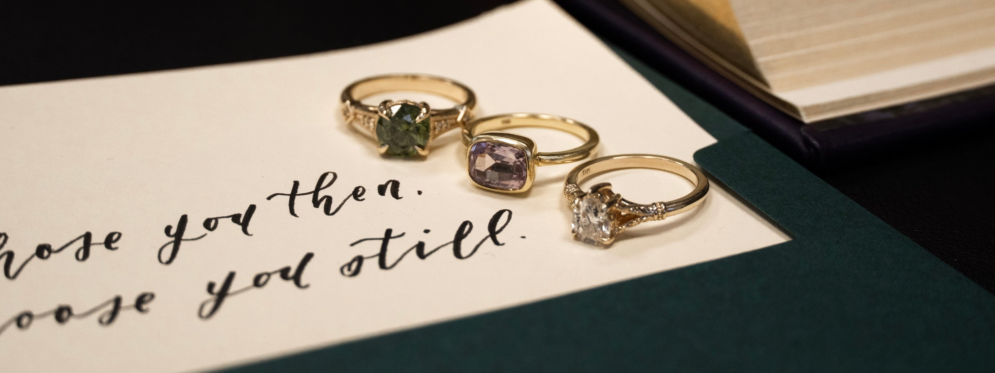 Vintage-inspired gemstone (sapphire and spinel) and diamond rings arranged on a handwritten love letter card, romantic heirloom fine jewellery.