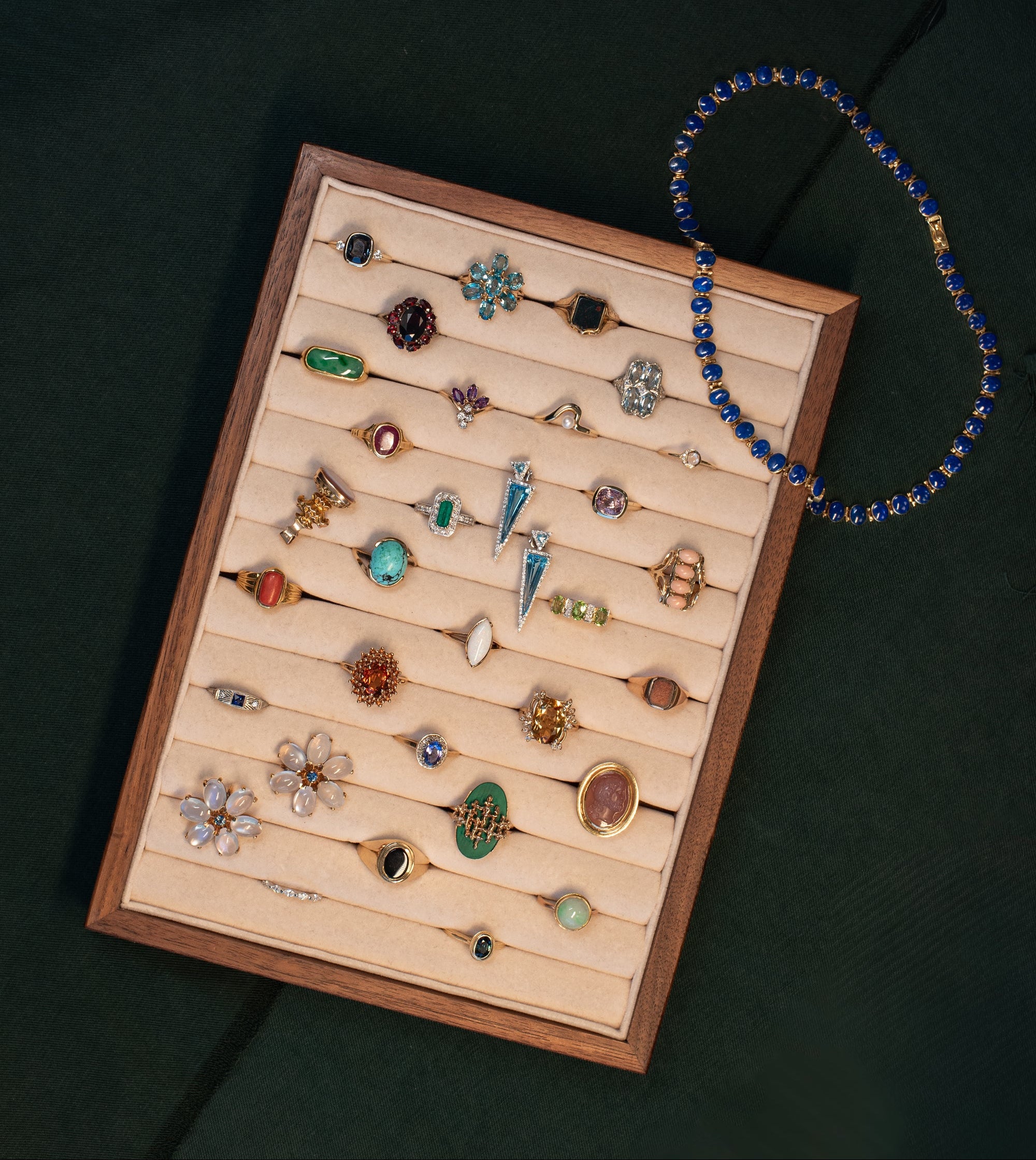 Wooden jewelry display tray with a selection of birthstone jewellery, including alternates for each month. 