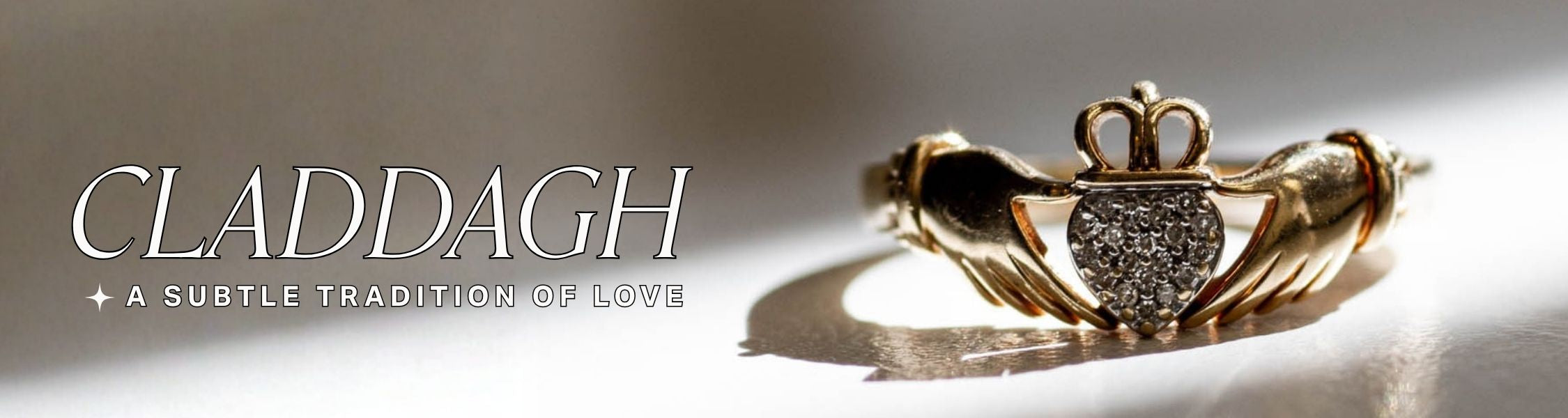 Gold Claddagh ring with pave diamond heart on a shadowy light background, text over reads: 'Claddagh, a subtle tradition of love'.