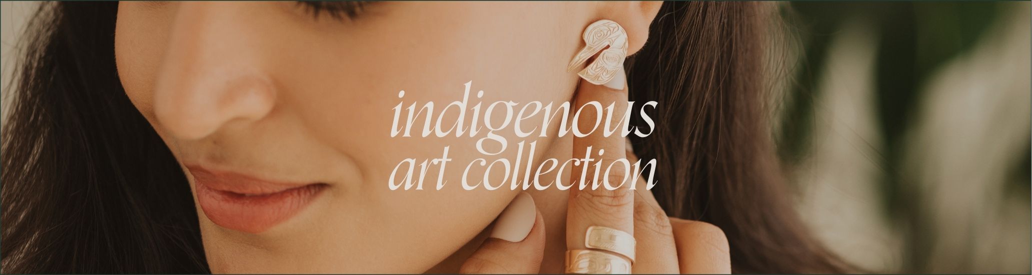 Close-up of a woman wearing earrings and ring with indigenous art motifs. Text overlay reads 'indigenous art collection'
