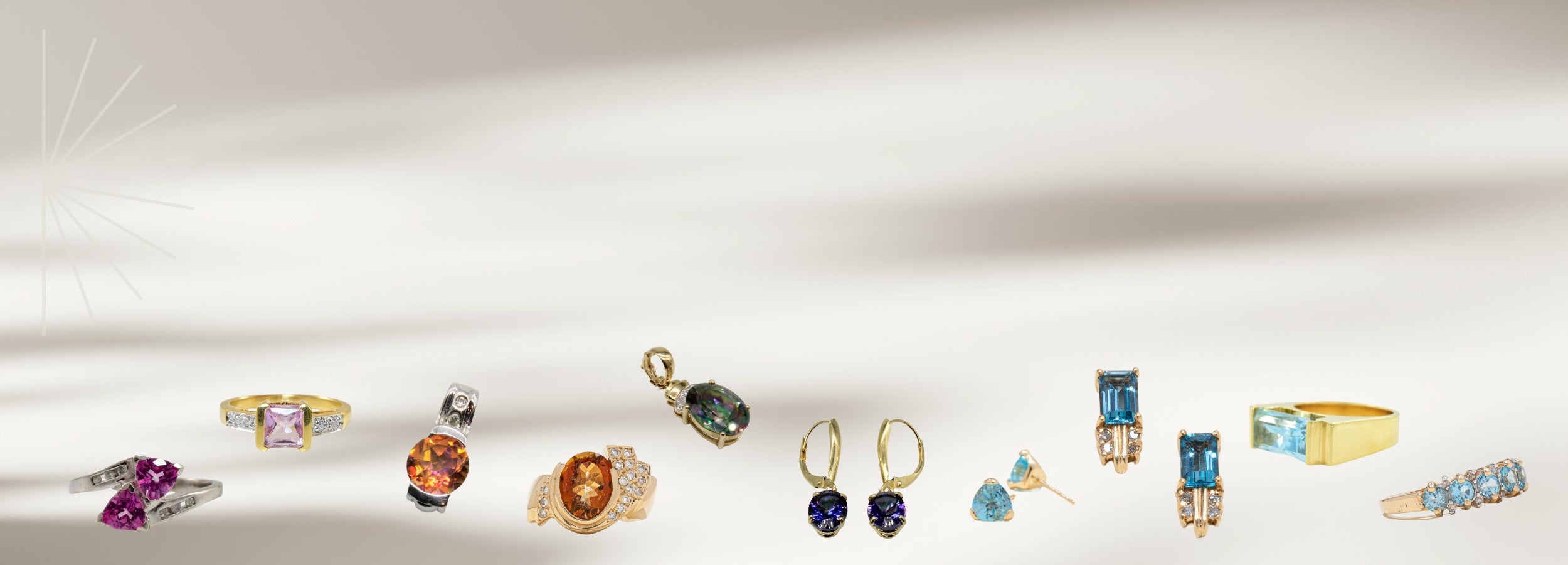 Image of cascading assortment of topaz jewelry featuring the range of shades the stone comes in